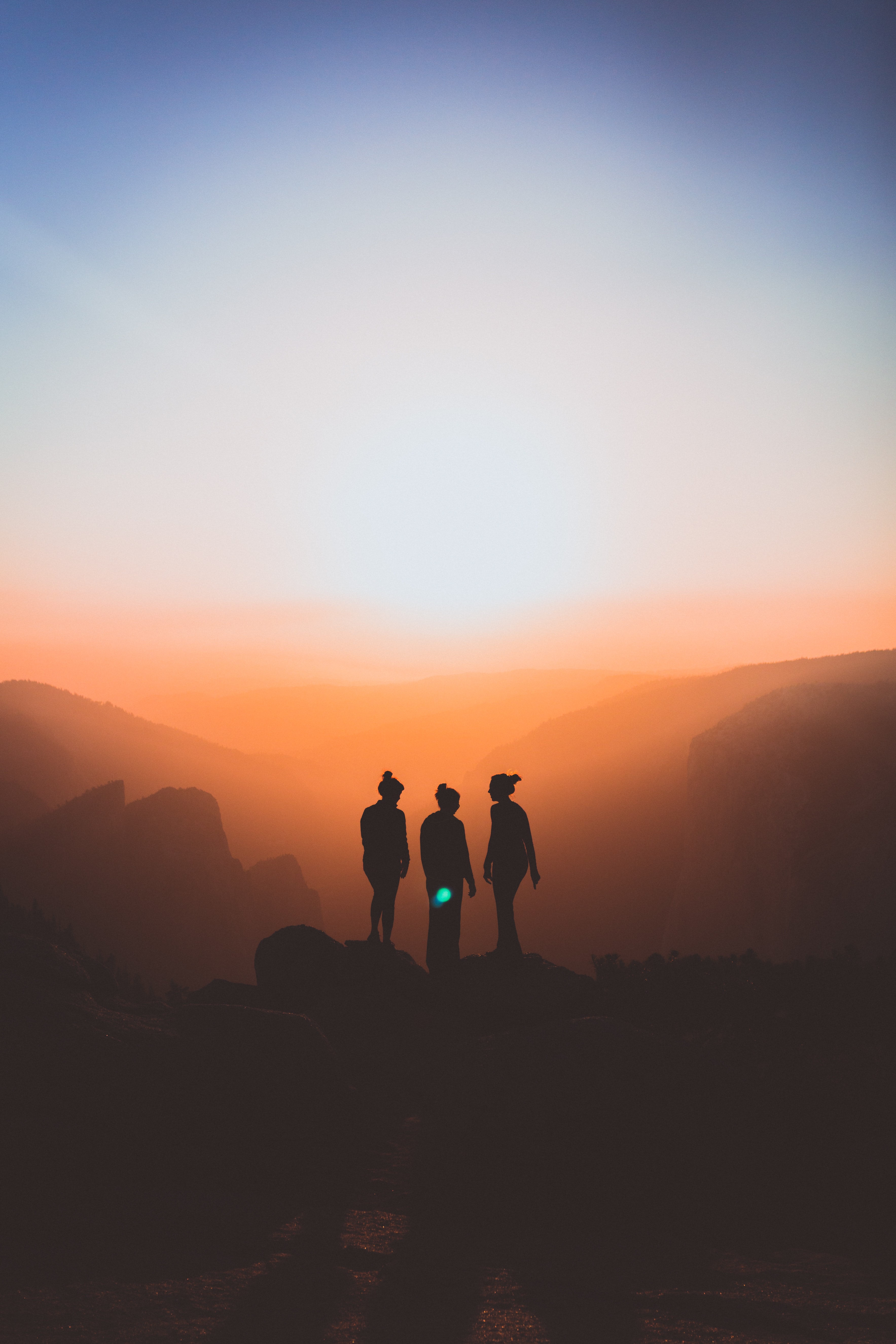 Silhouette of three women on a mountain; image by Karl Magnuson, via Unsplash.com.