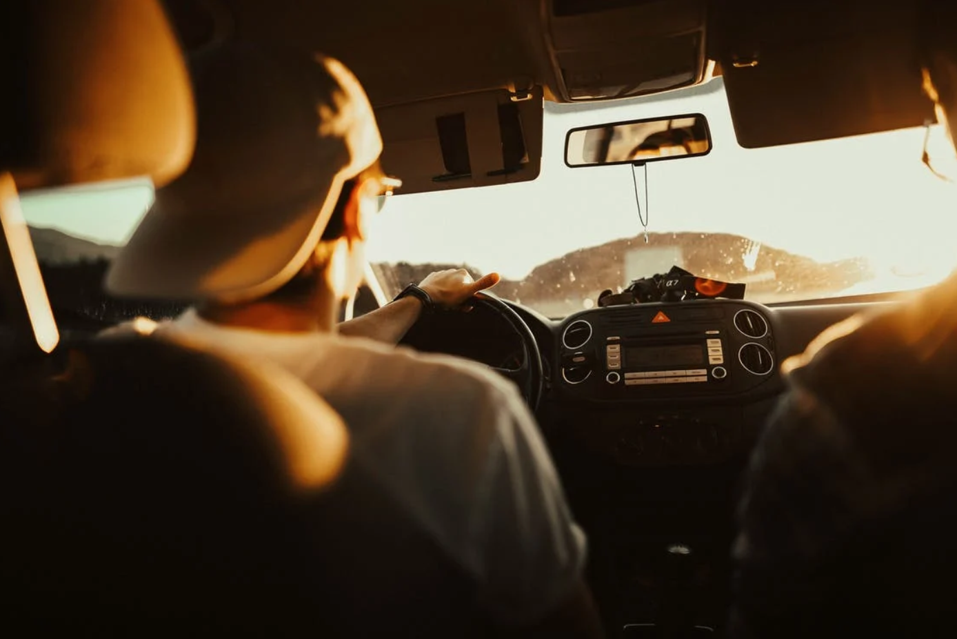 Man holding steering wheel while driving; image by Tobi, via Pexels.com.