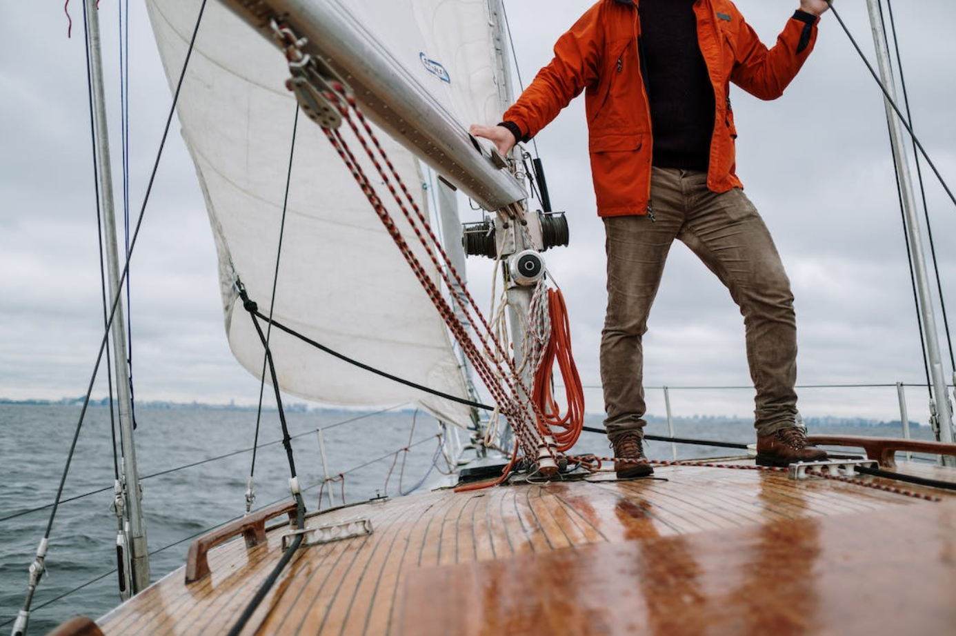 Man on deck of sailboat on the water; image by Cottonbro Studio, via Pexels.com.