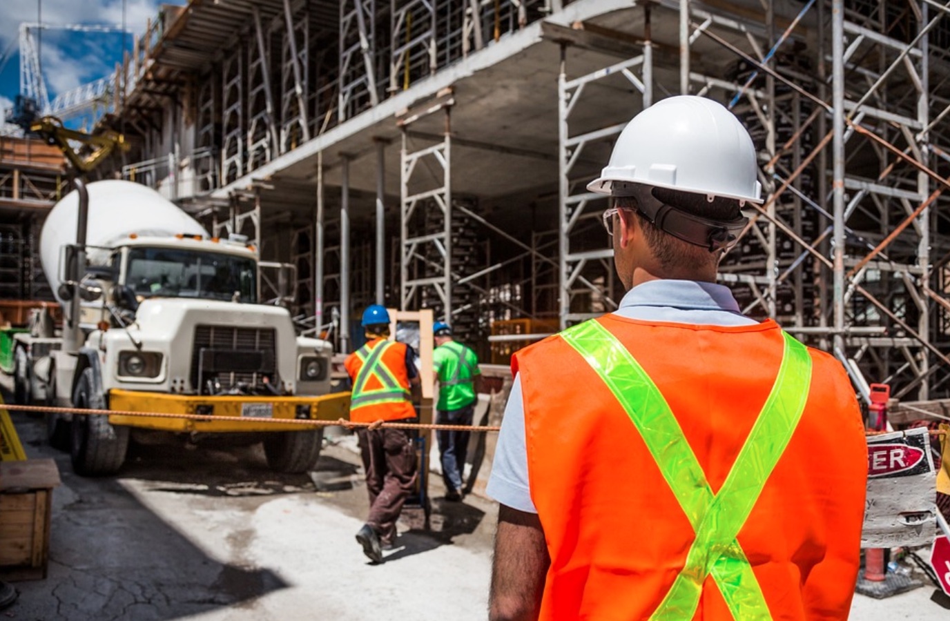 Men in safety gear on construction site; image by Bridgesward, via Pixabay.com.