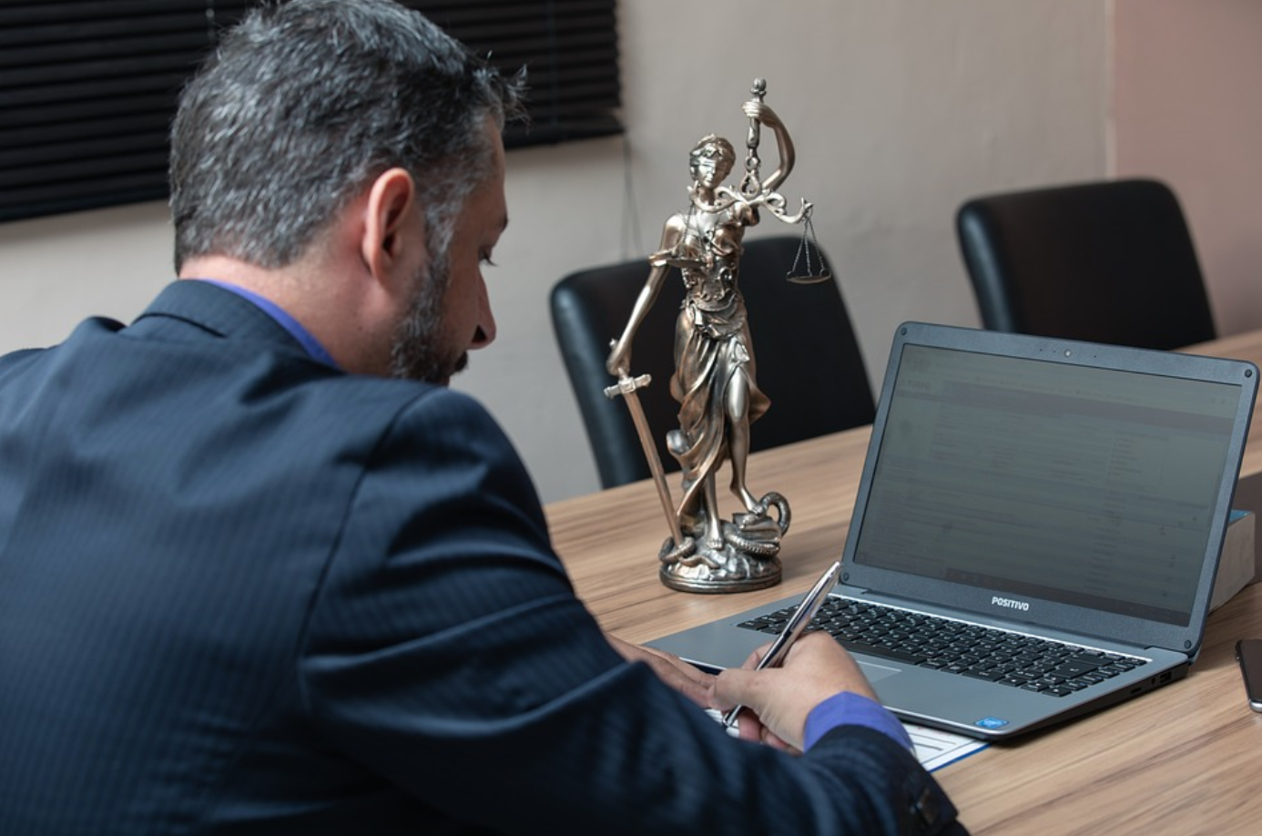 Lawyer at desk writing; image by advogadoaguilar, via Pixabay.com.