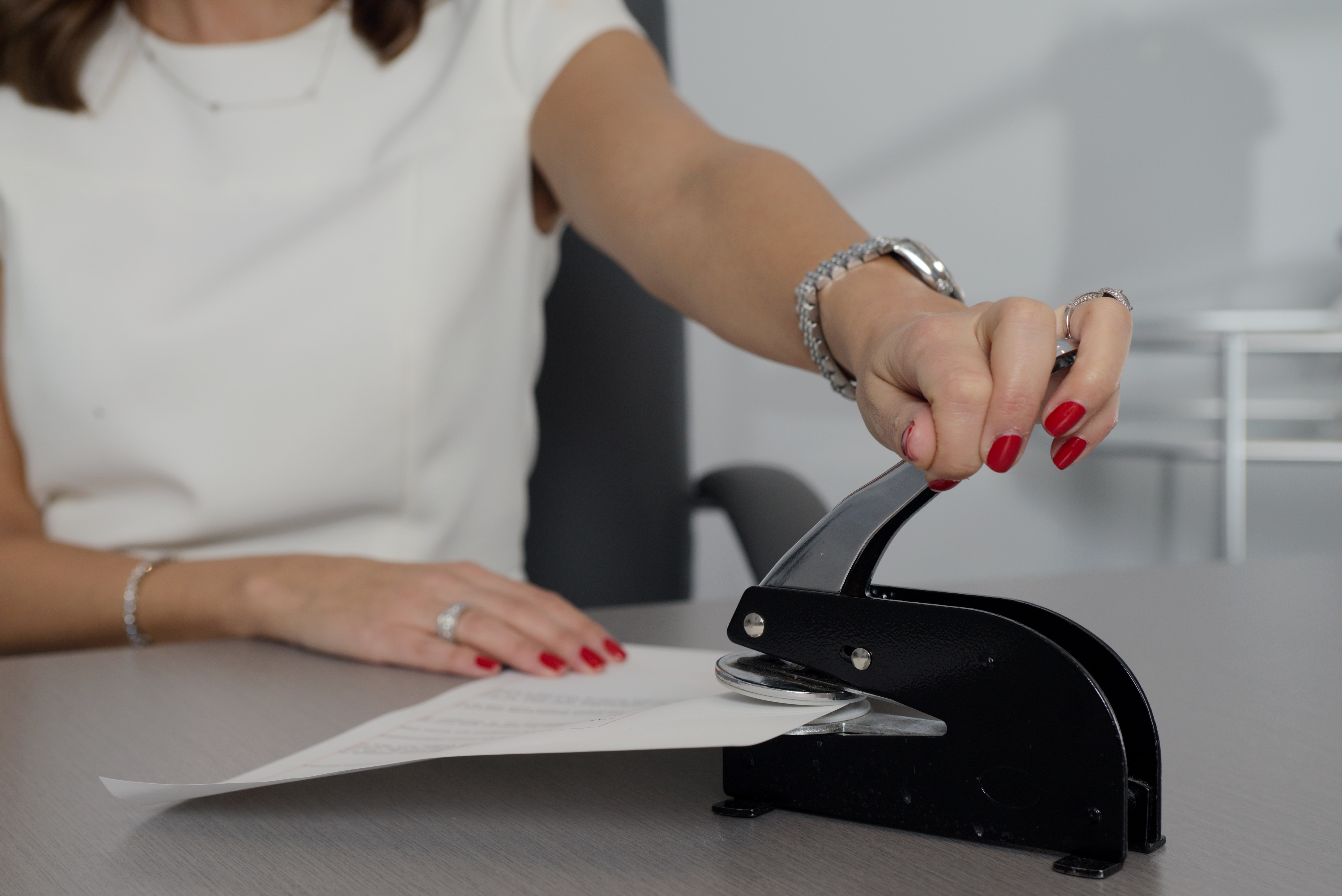Notary putting a professional seal on a legal document; image by Stephen Goldberg, via Unsplash.com.