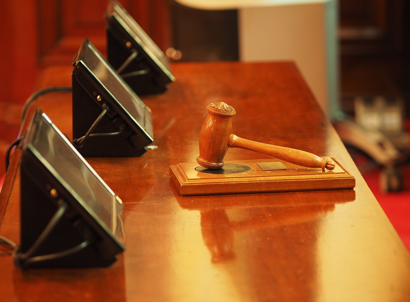 Gavel and tablets on desk in courtroom; image by Daniel B Photos, via Pixabay.com.