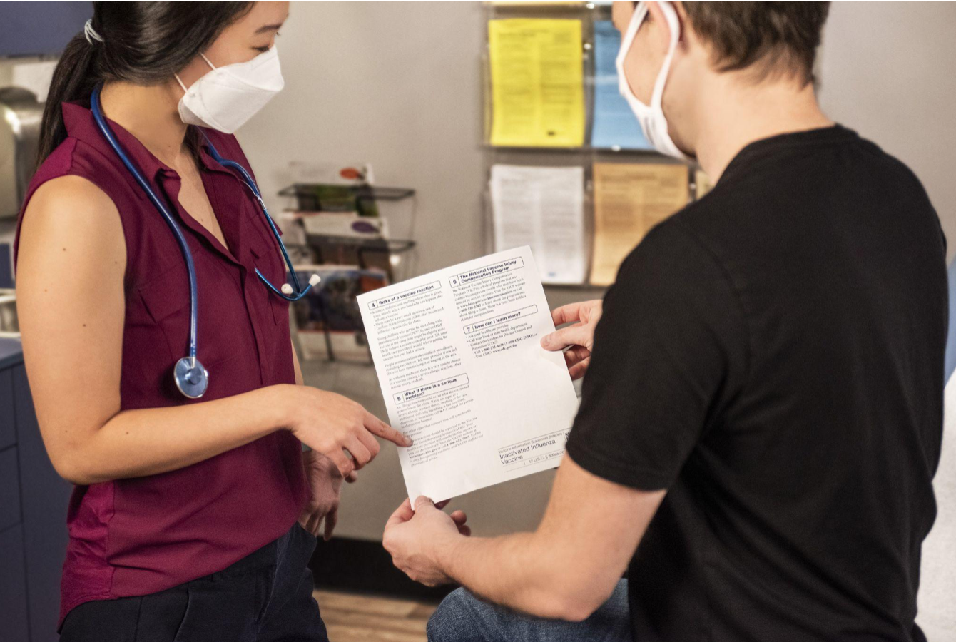 Healthcare provider and patient going over paperwork; image by CDC, via Unsplash.com.