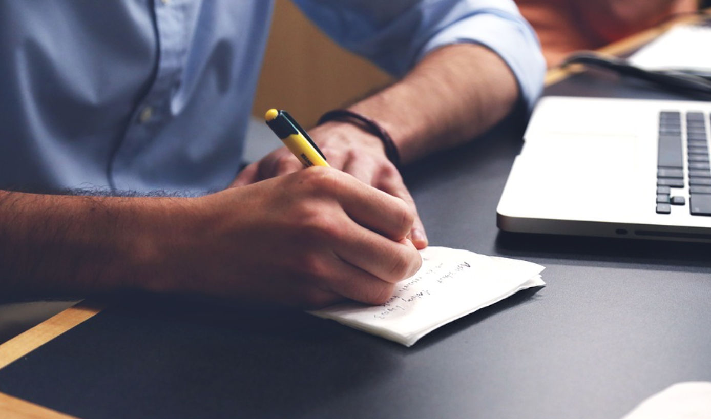 Man taking notes; image by StartupStockPhotos, via Pixabay.com.