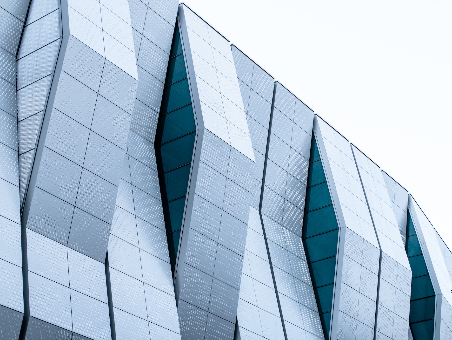 Teal windows and silver paneling on the exterior of the Golden1 Center arena; image by Meritt Thomas, via Unsplash.com.