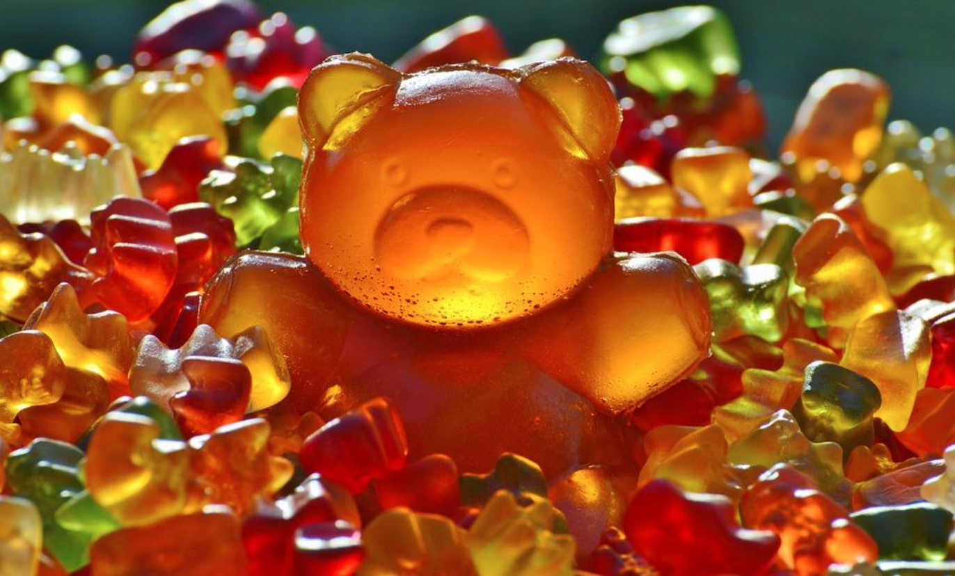 Giant gummy bear surrounded by smaller gummy bears; image by Alexas_Fotos, via Pixabay.com.