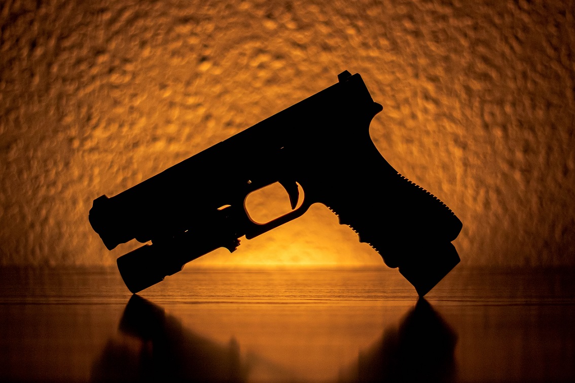 The backlit silhouette of a handgun.