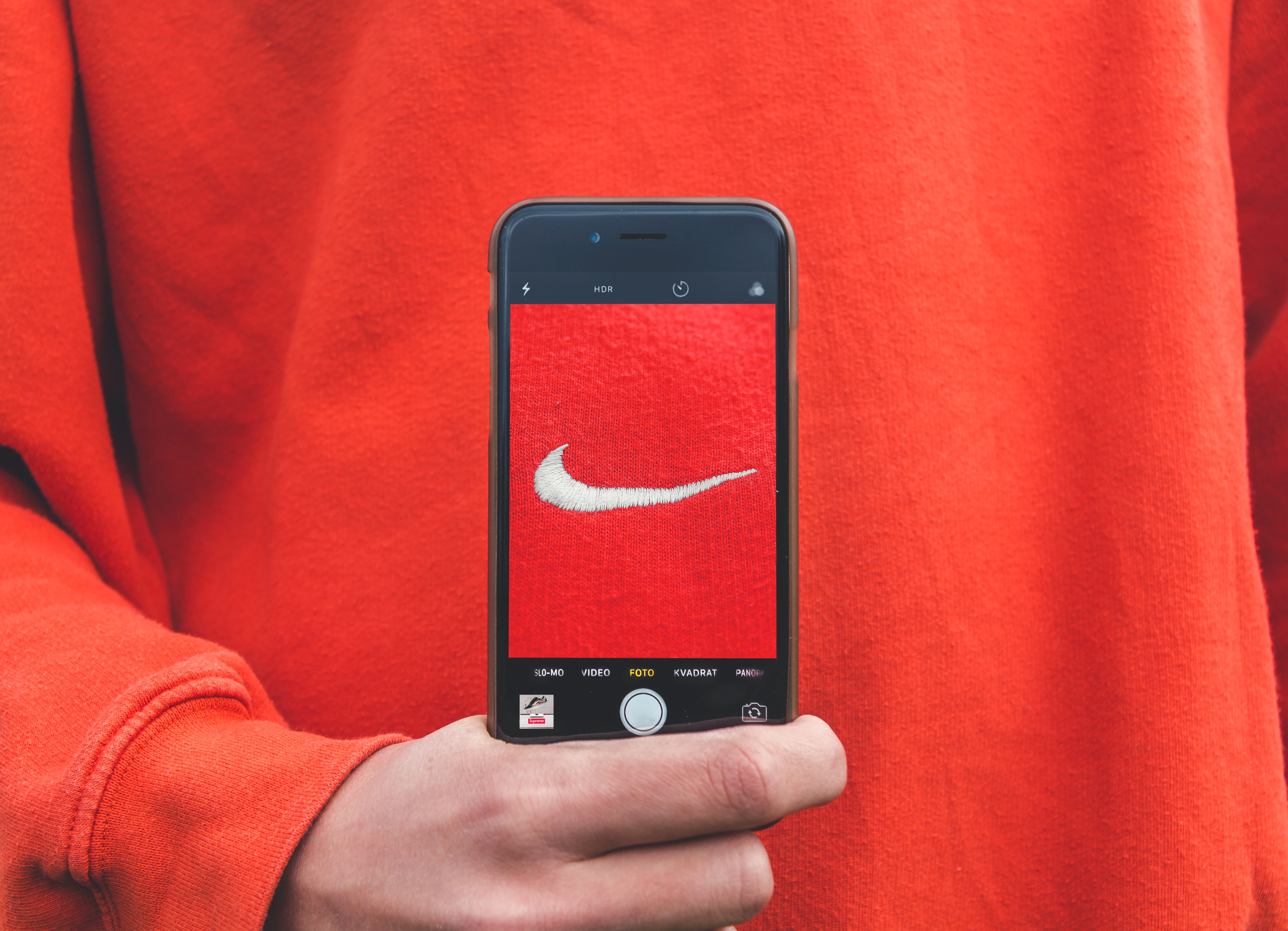 Person with cellphone and Nike logo; image by Kristian Egelund, via Unsplash.com.
