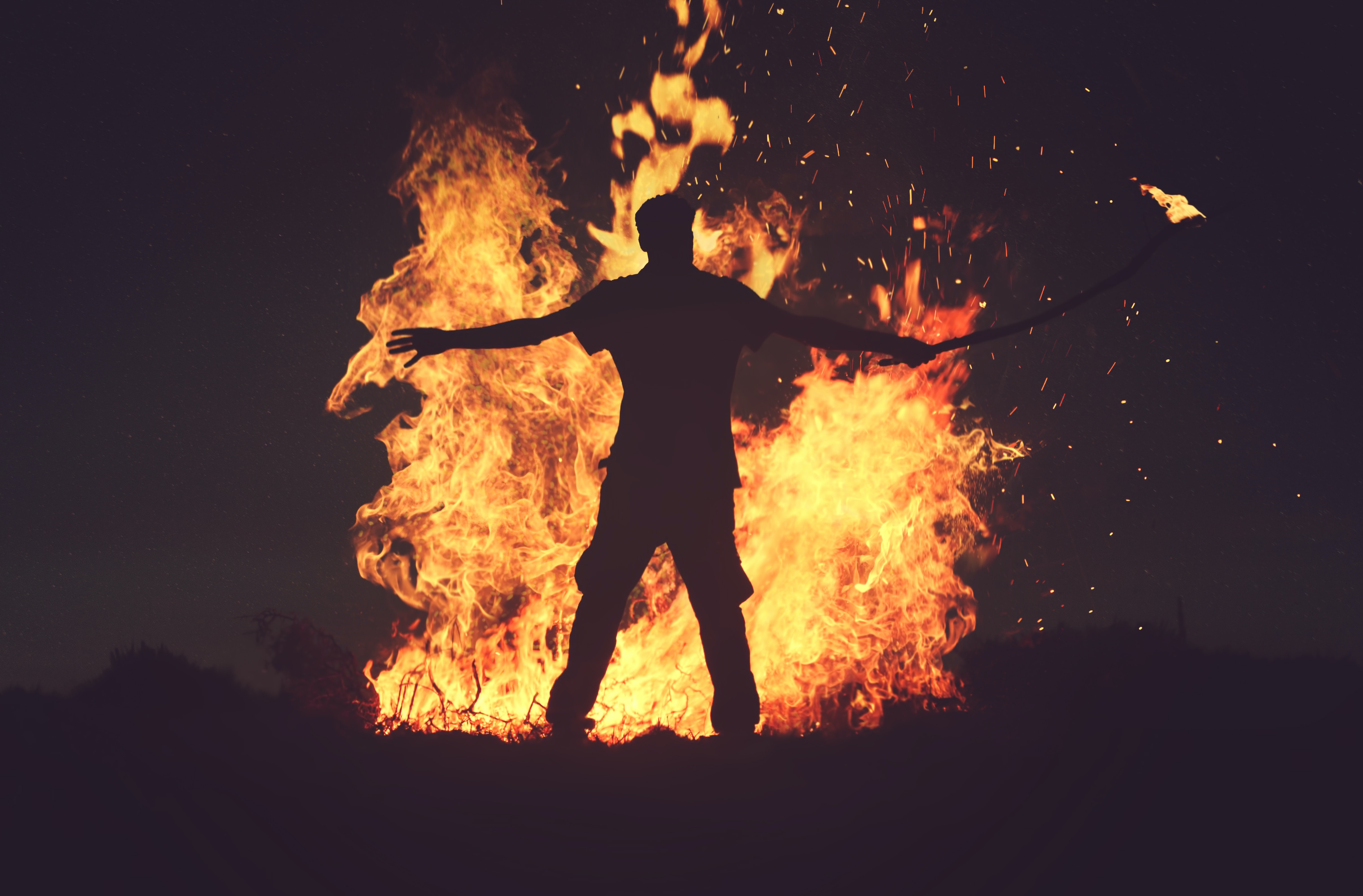 The shape of a person in silhouette against a large fire.