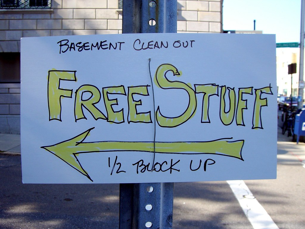 A handwritten sign that says "Basement cleanout - Free Stuff 1/2 block up."