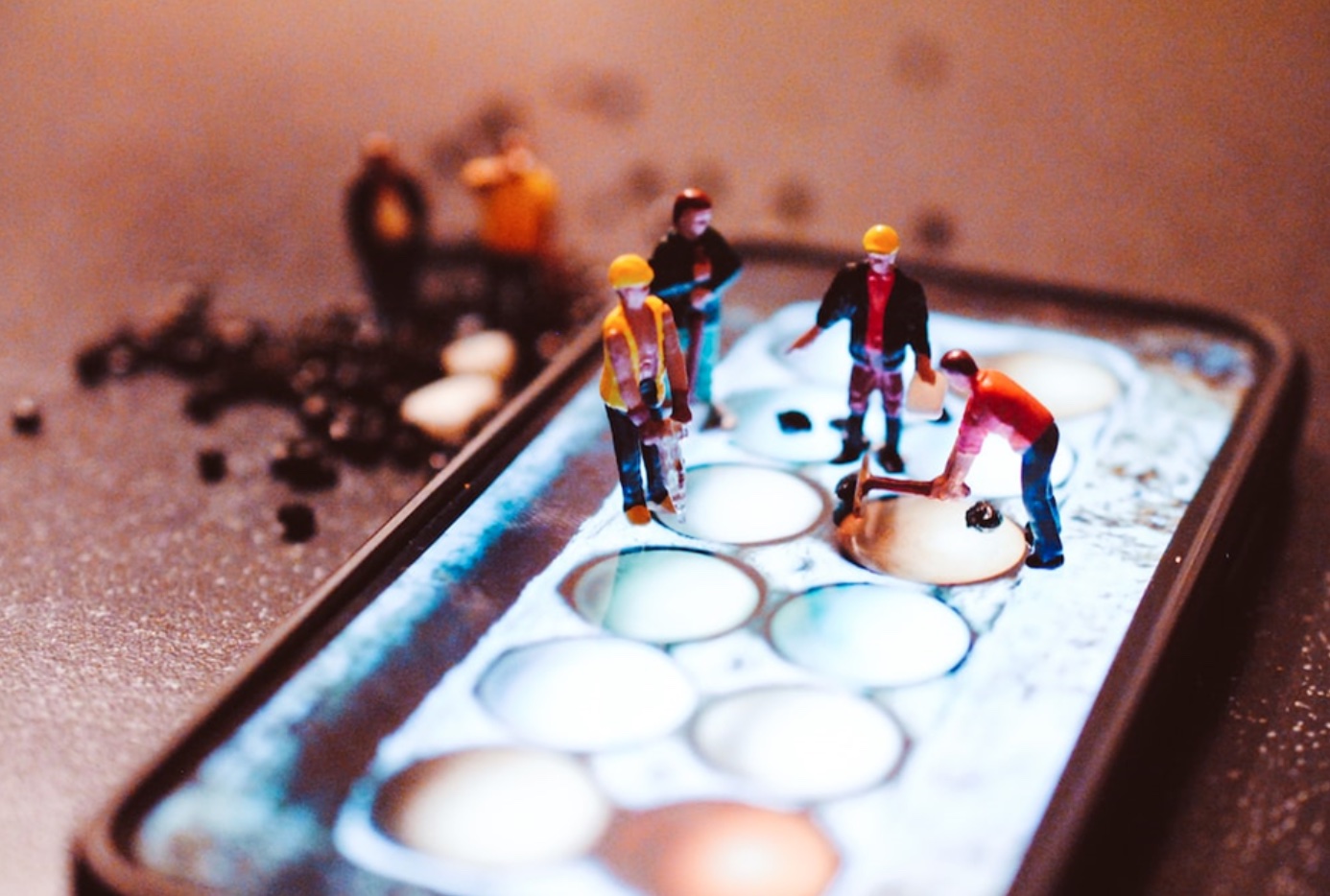 Tiny model construction workers, working on a mobile phone screen; image by Nik, via Unsplash.com