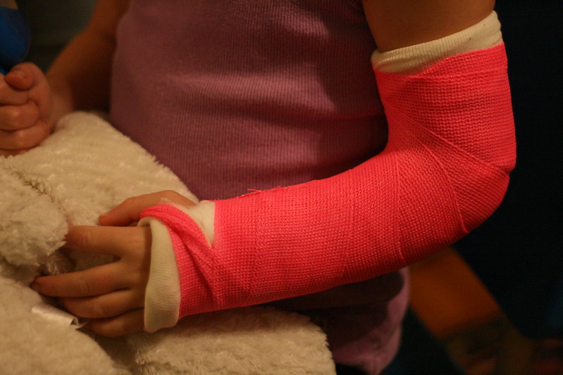 Girl in pink cast; image by Alex Ragone, via Flickr.com, CC BY-NC-SA 2.0 Deed, no changes made.