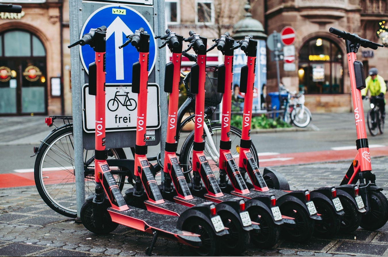 A row of black and red e-scooters; image by Markus Spiske, via Unsplash.com.