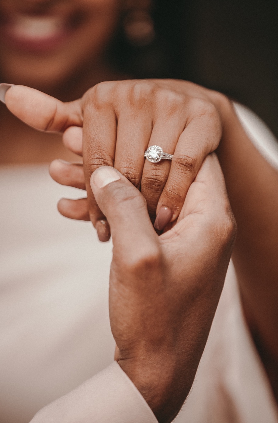 Couple holding hands, showing diamond ring; image by Alekon Pictures, via Unsplash.com.