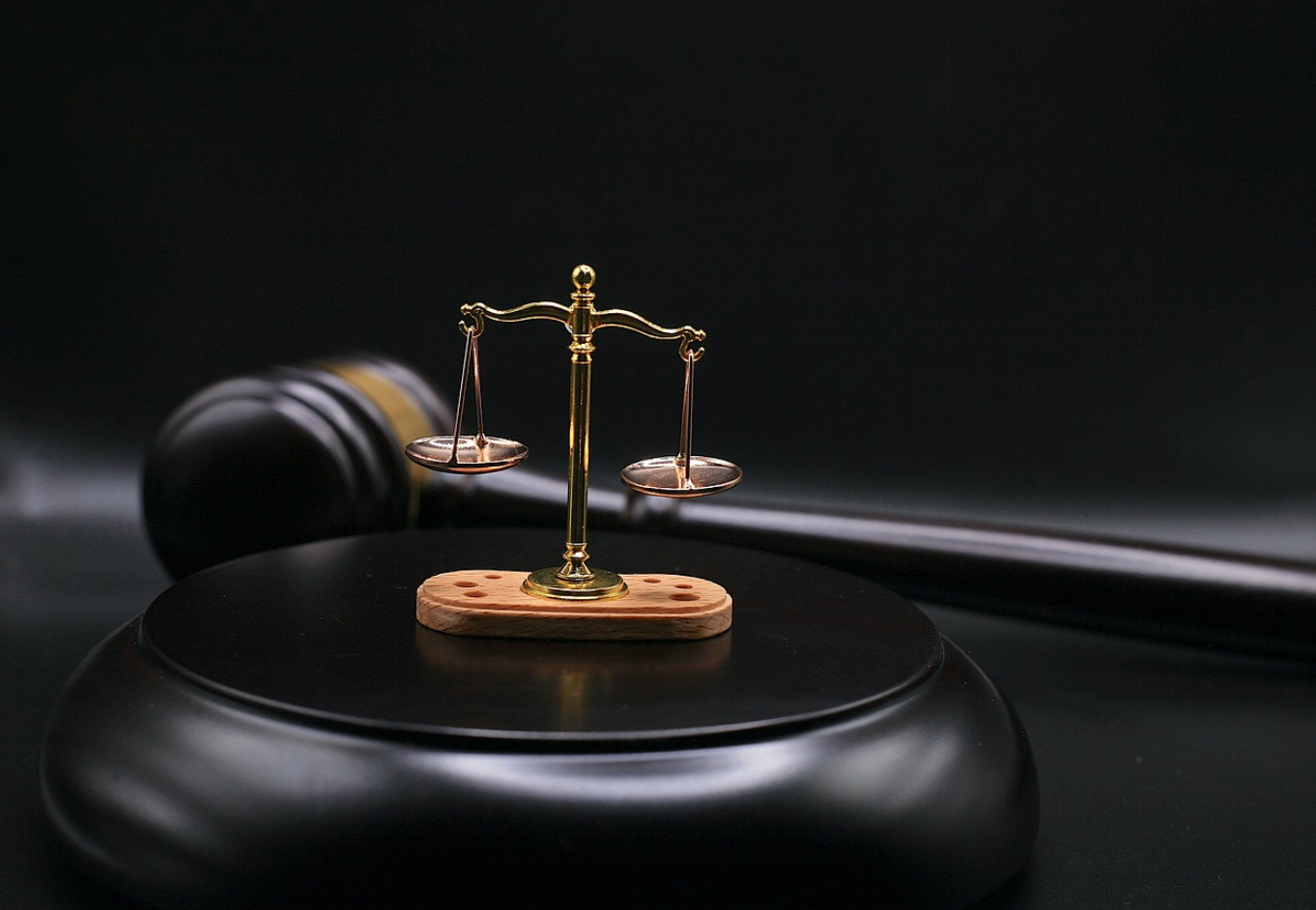 Gavel next to miniature scales of justice; image by sergeitokmakov, via Pixabay.com.