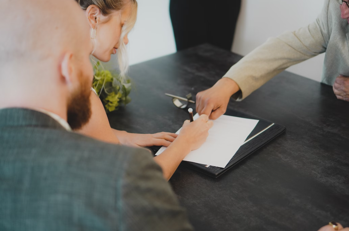 Signing paperwork; image by Annika Wischnewsky, via Unsplash.com.