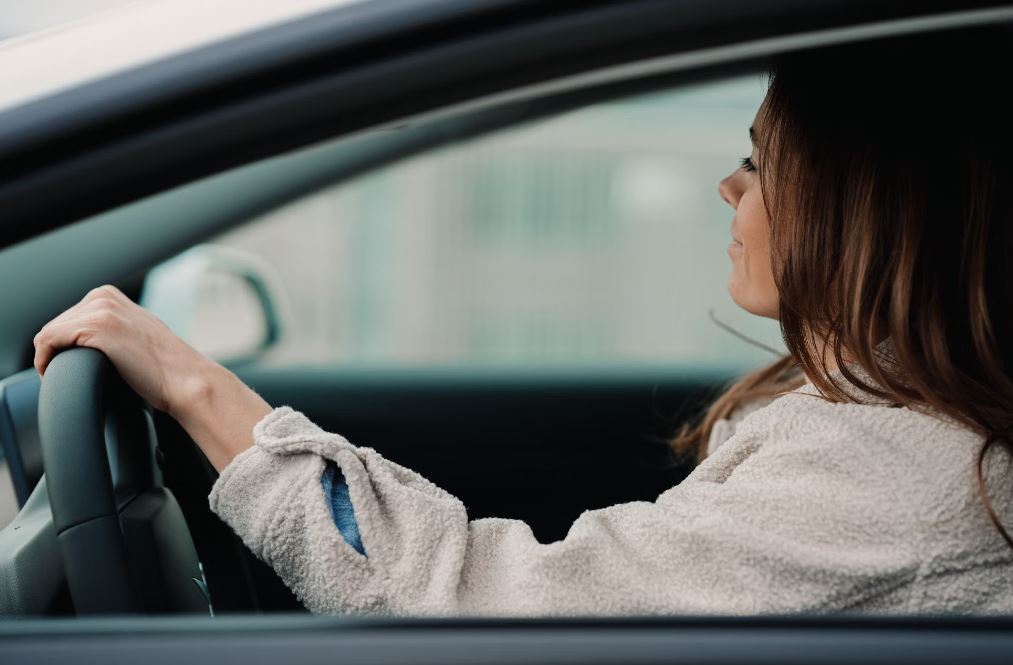 Woman in gray hoodie sitting inside car during daytime; image by Jenny Ueberberg, via Unsplash.com.