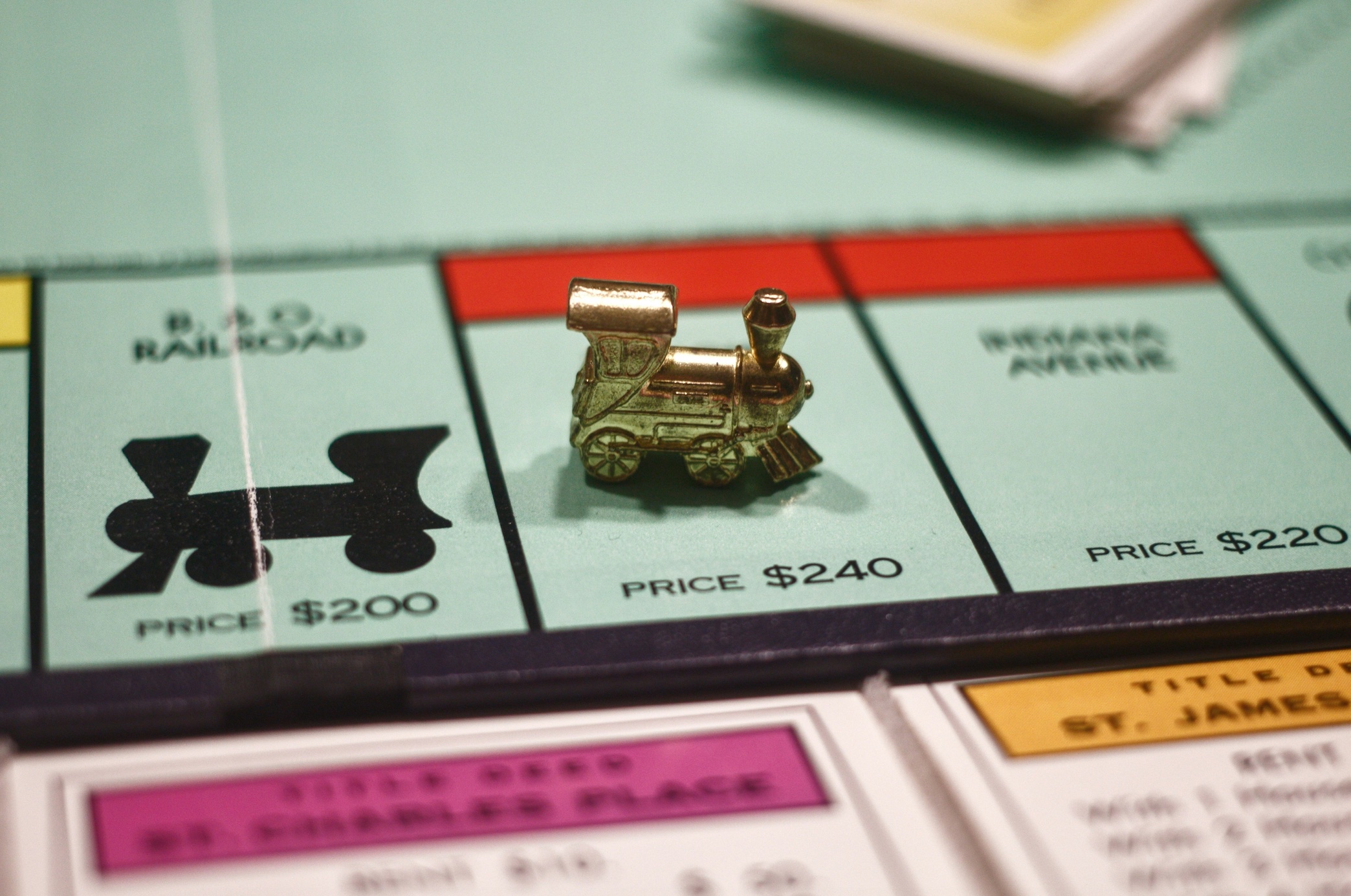 Close-up of Monopoly board game with train piece; image by Joshua Hoehne, via Unsplash.com.