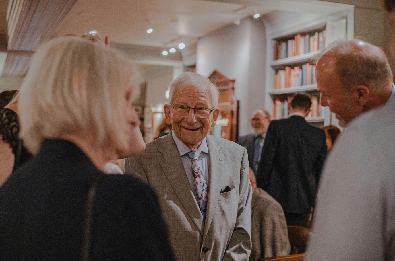 Older man at gathering; image by Abi Howard, via Unsplash.com.