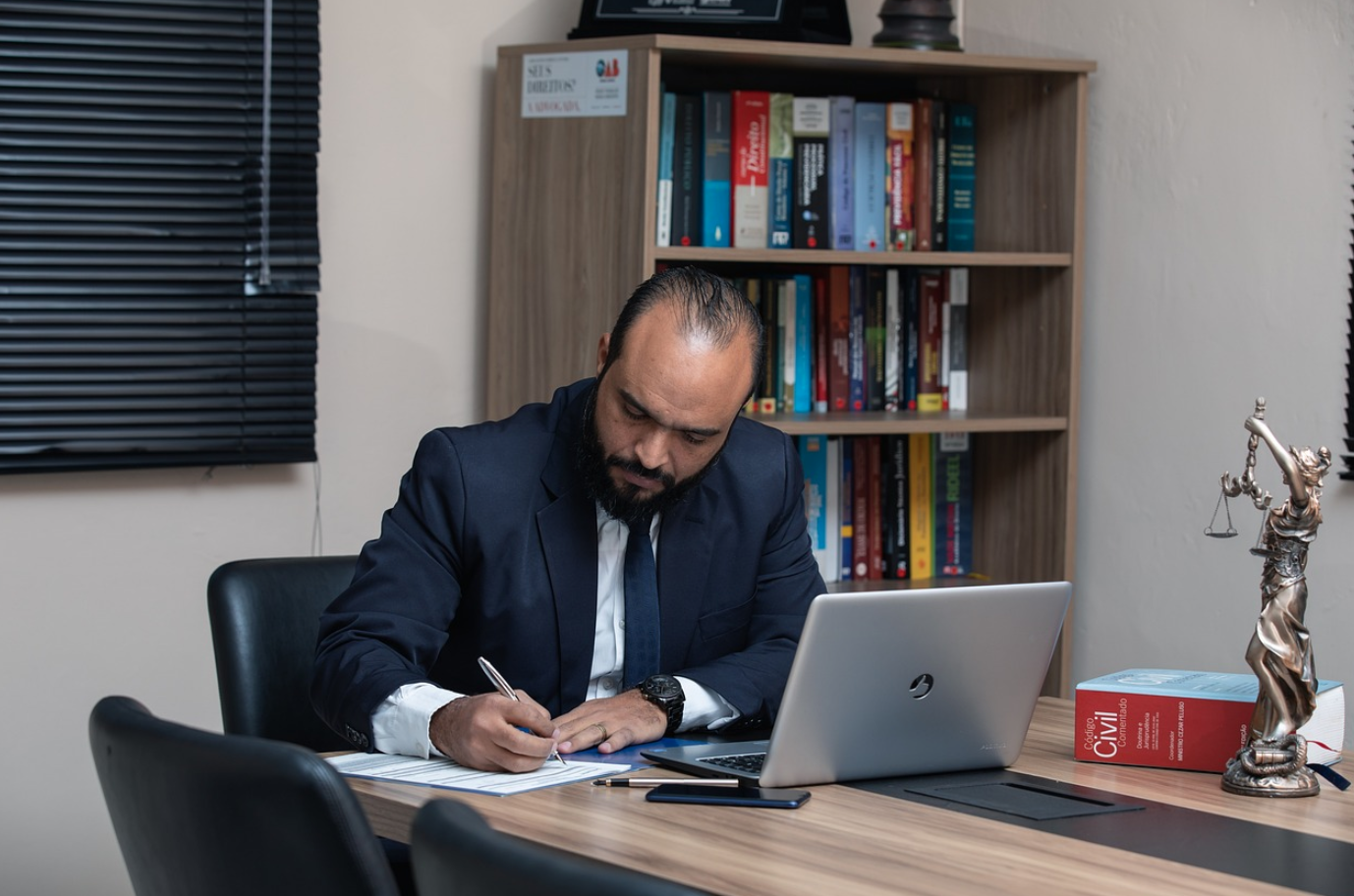 Lawyer sitting at desk with laptop; image by advogadoaguilar, via Pixabay.com.