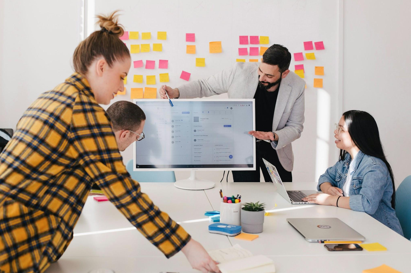 Team looking at computer monitor; image by Jason Goodman, via Unsplash.com.