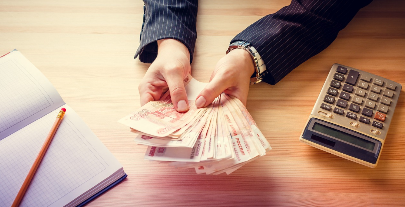 Woman with notebook and calculator counting money; image by Daria-Yakovleva, via Pixabay.com.