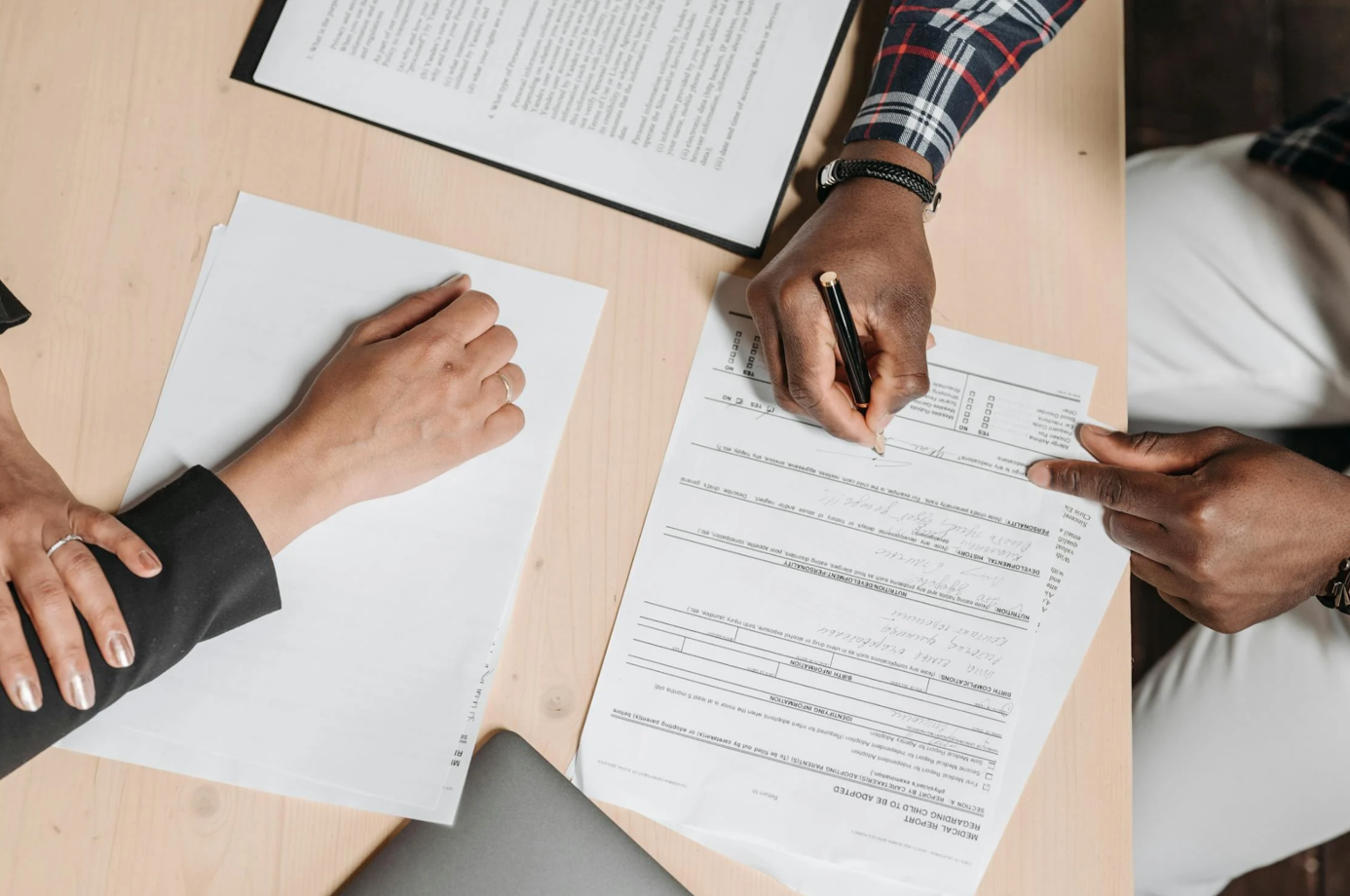 Two people doing paperwork; image by Pavel Danilyuk, via Pexels.com.