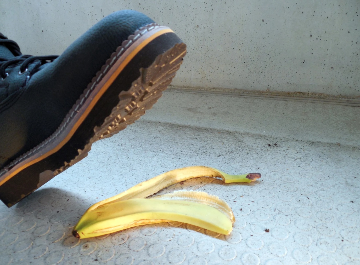 Person in work boot about to step on banana peel; image by succo, via Pixabay.com.