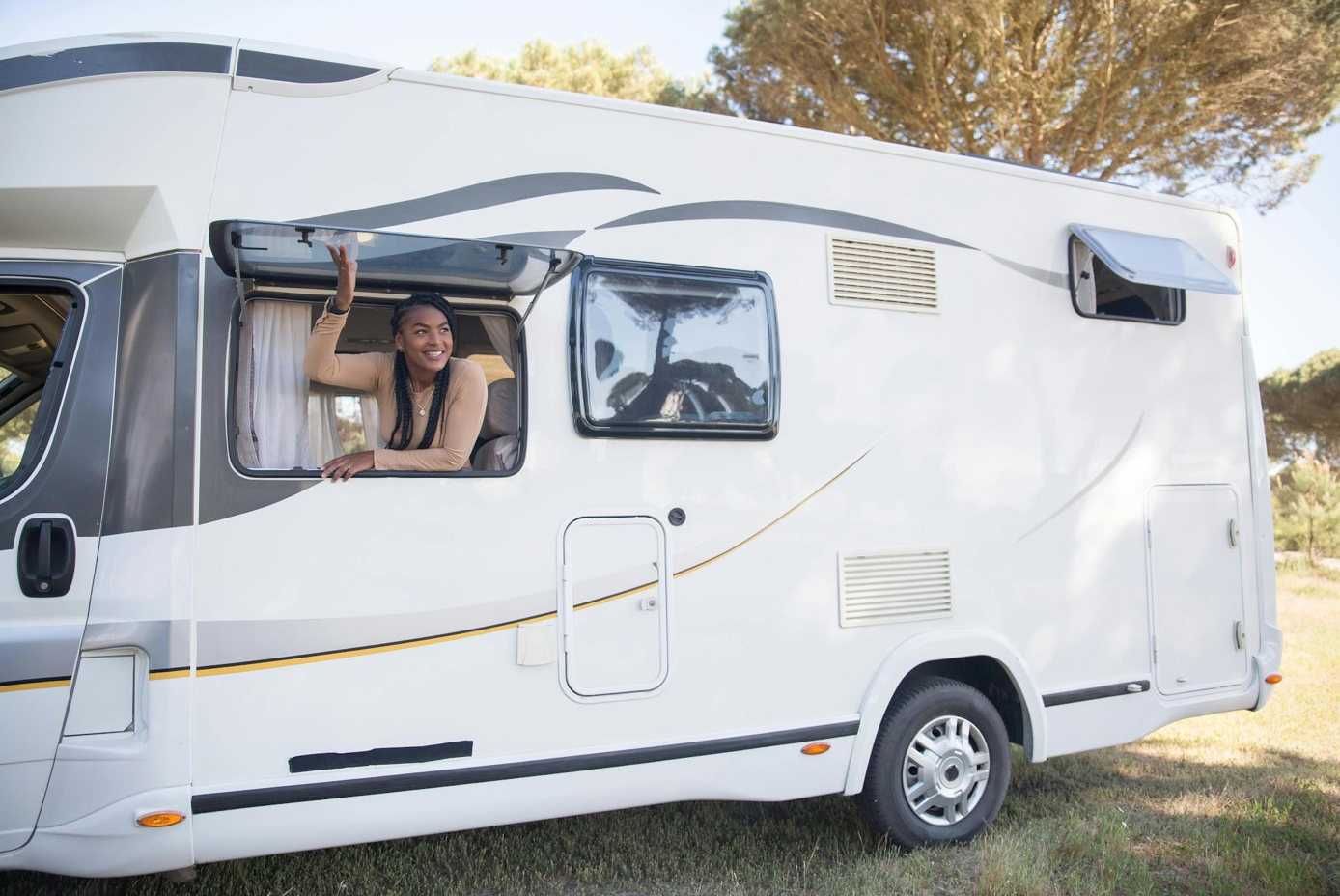 Woman sitting by caravan window; image by Kampus Production, via Pexels.com.