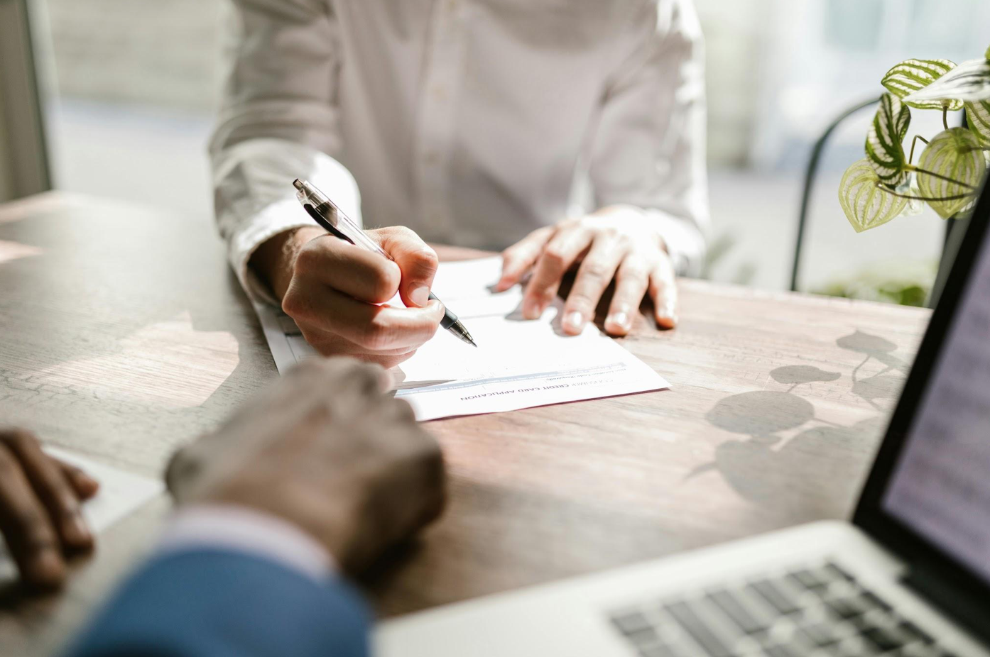 Close up of someone signing a document; image by RDNE Stock project; via Pexels.com.