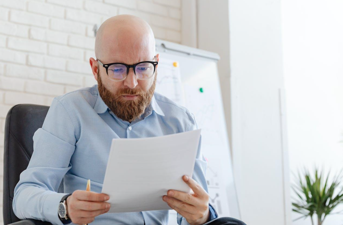 Man looking at documents; image by Karola G, via Pexels.com.