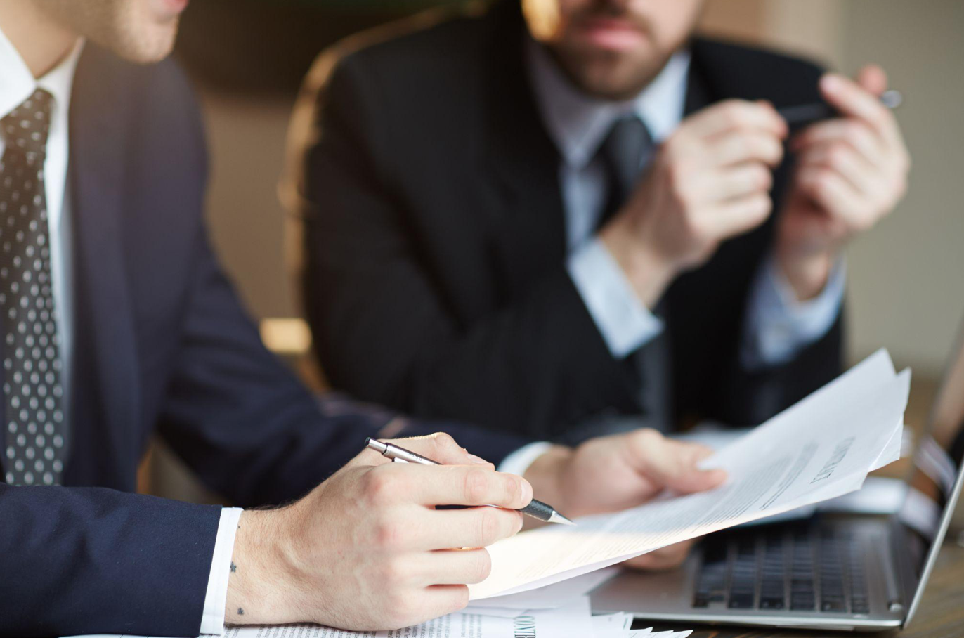 Two men discussing paperwork; image by pressfoto, via Freepik.com.