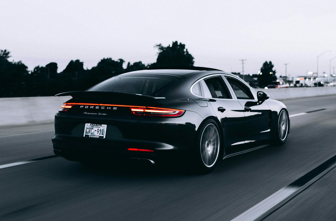 Black Porsche sedan on road; image by Campbell, via Unsplash.com.