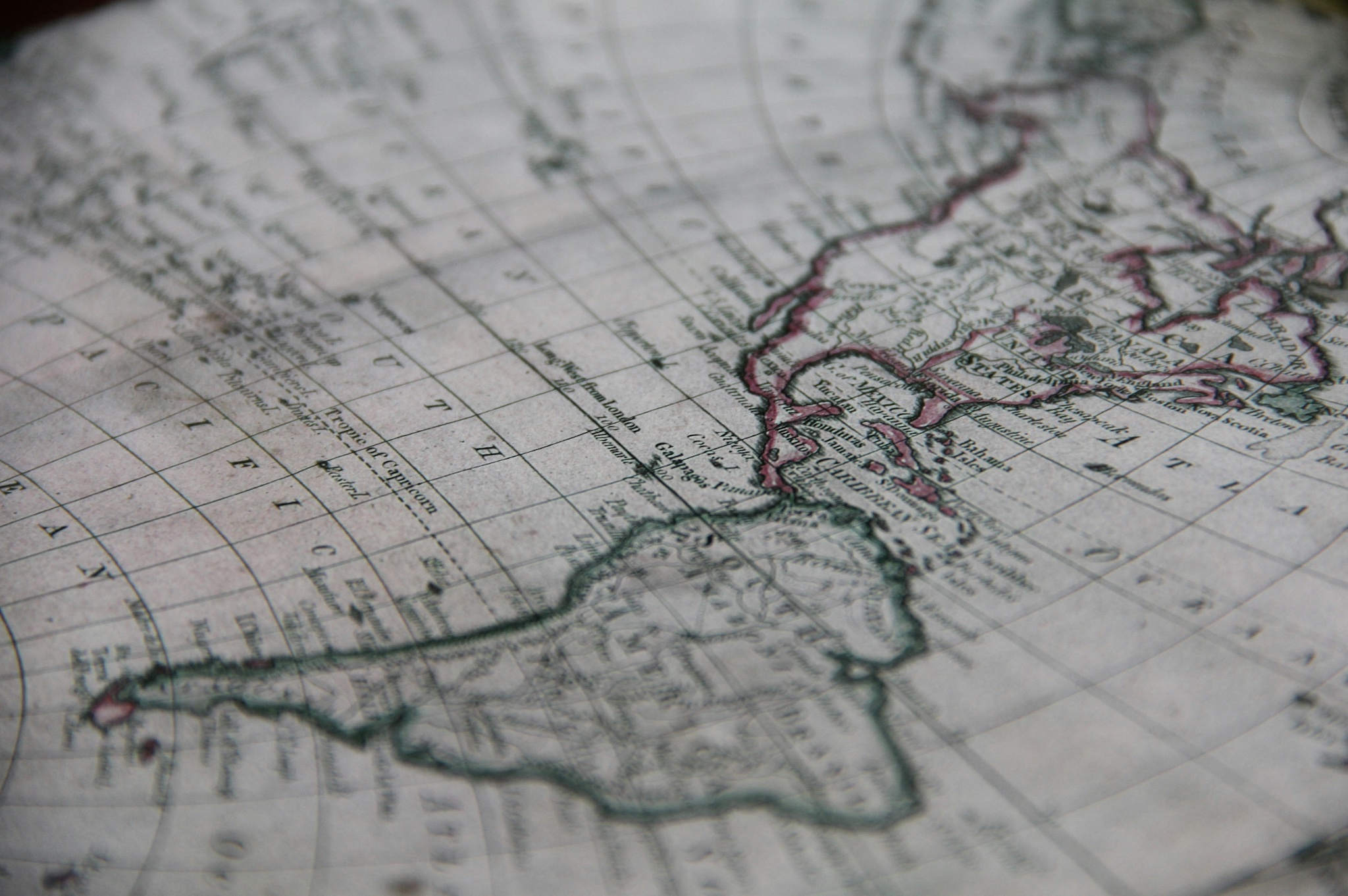 Greyscale close-up of world map highlighting North and South America; image by Leon Overweel, via Unsplash.com.