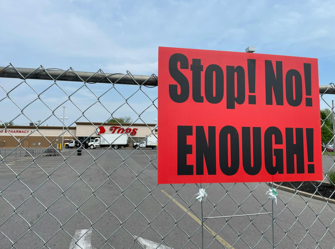 Red sign posted on chainlink fence, saying in black letters; image by Lisa Summerour, via Unsplash.com.