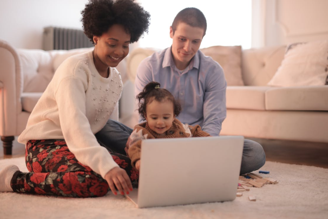 Family sitting on floor using laptop; image by Andrea Piacquadio, via Pexels.com.