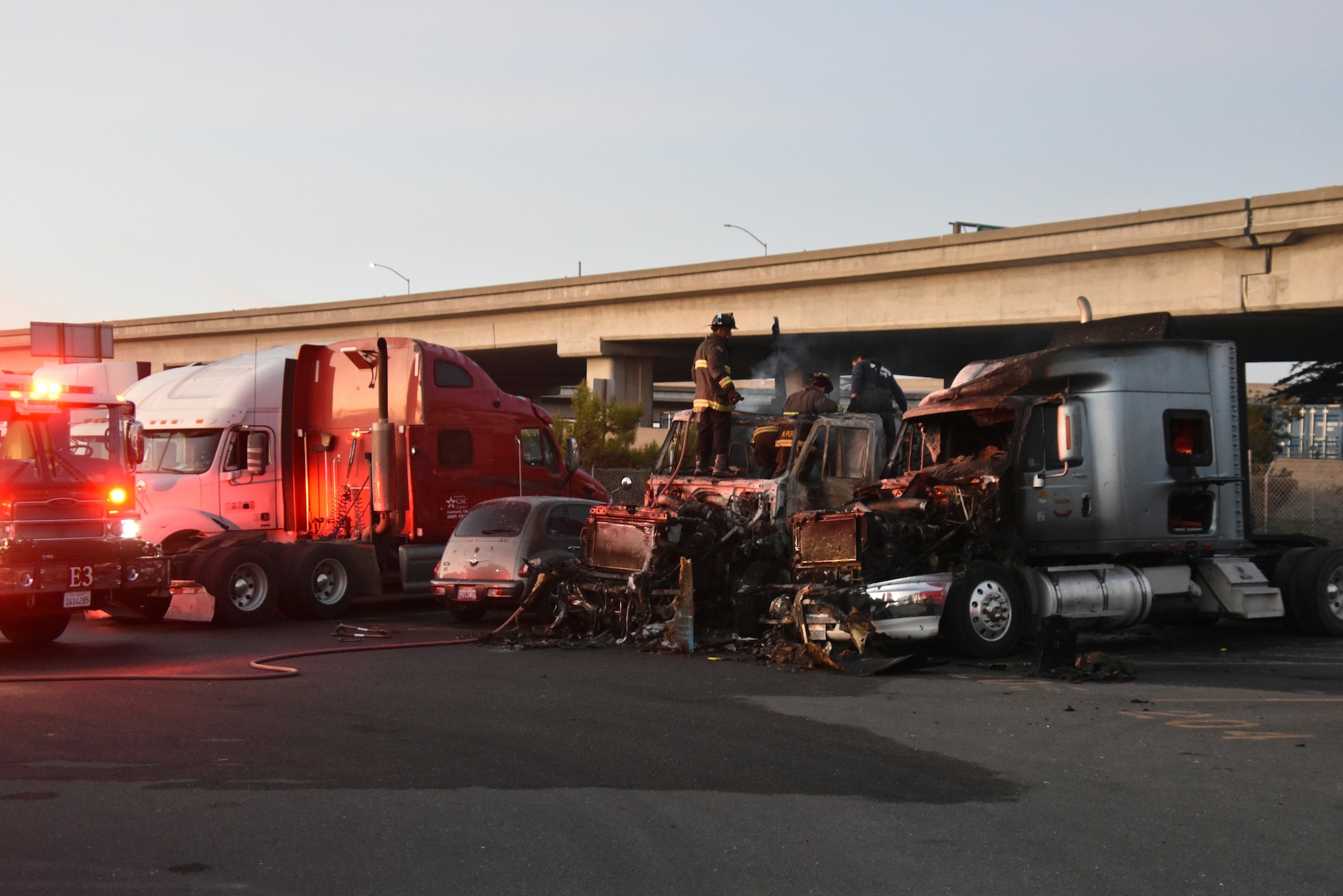 Trucks, some still smoking, and firefighters in a parking lot; image by Bill Aboudi, via Unsplash.com.