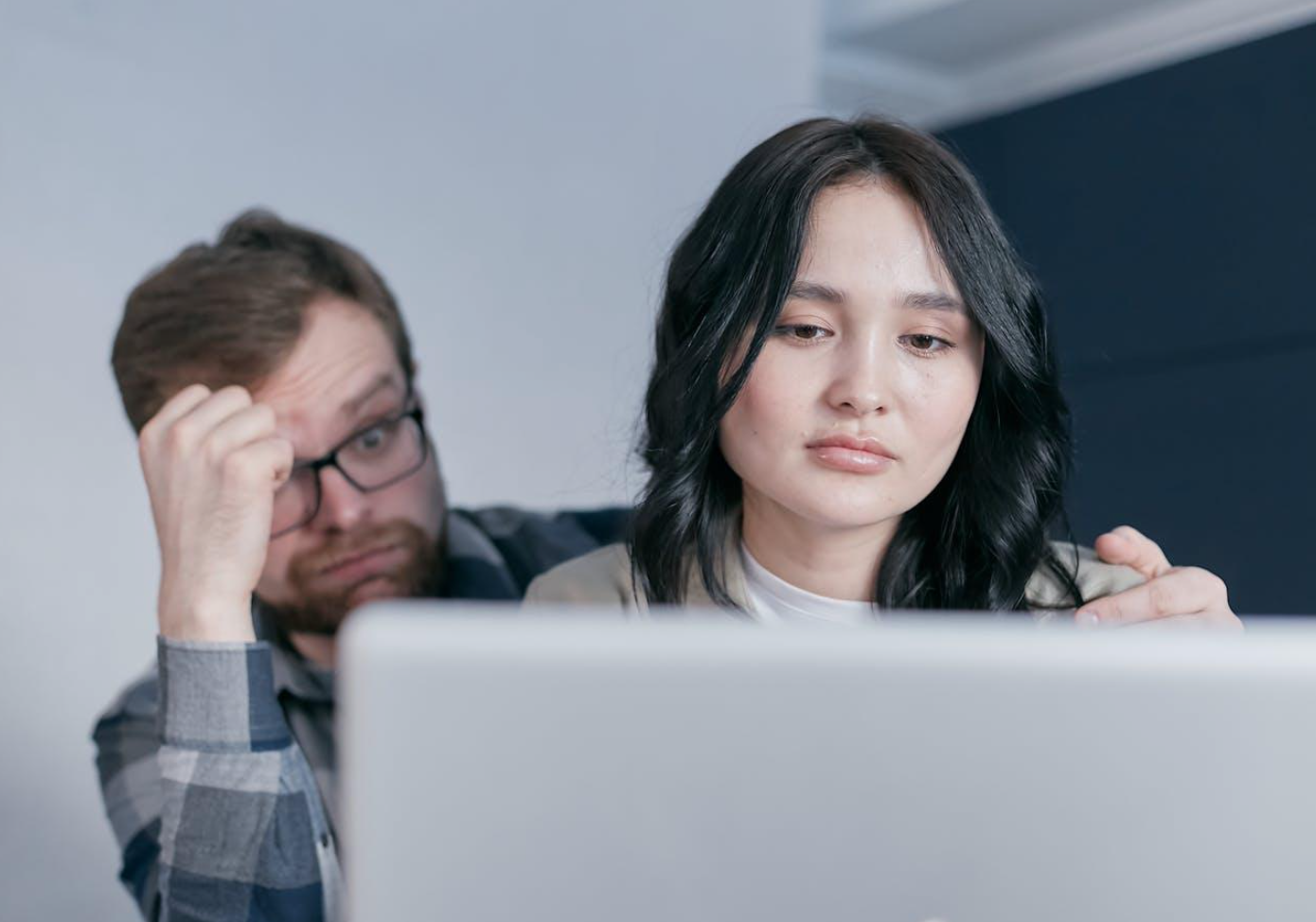 Man and woman looking at laptop; image by Mikhail Nilov, via Pexels.com.