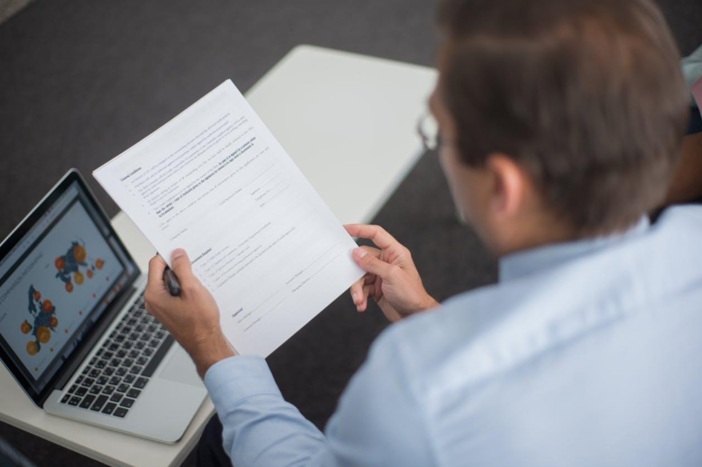 Man looking at documents; image by Kampus Production, via Pexels.com.