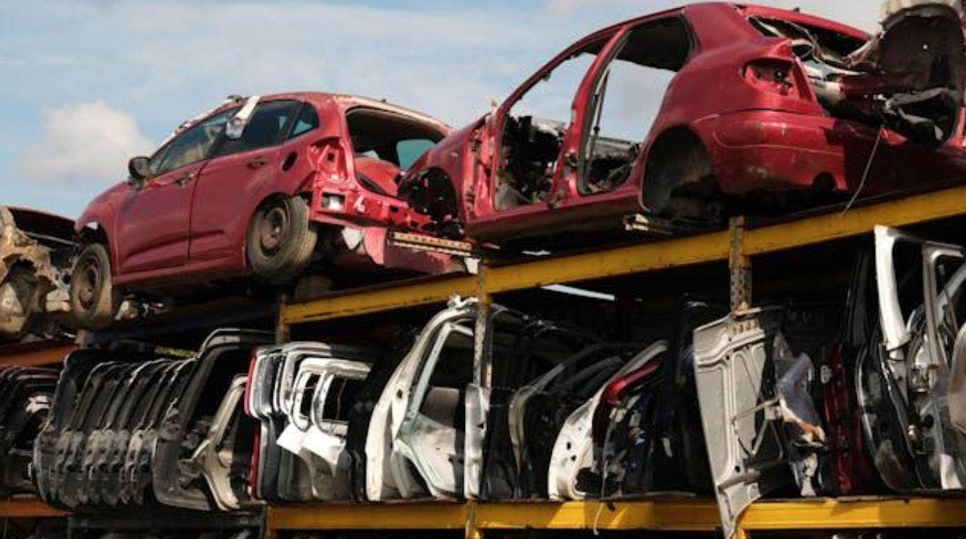 Stacked wrecked cars in a junkyard; image by Aziz Ur, via Pexels.com.