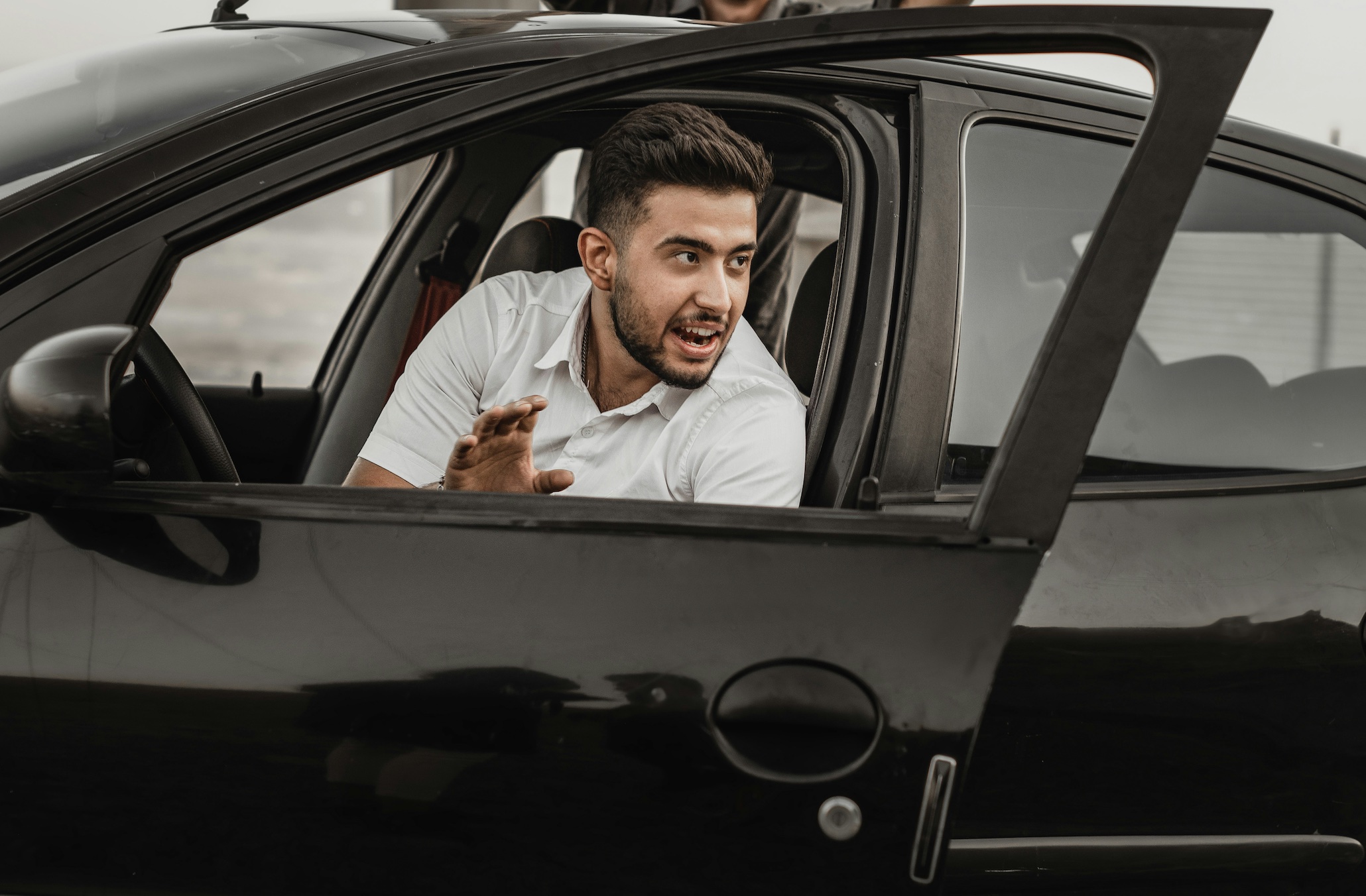Man getting out of his car; image by omid bonyadian, via Unsplash.com.