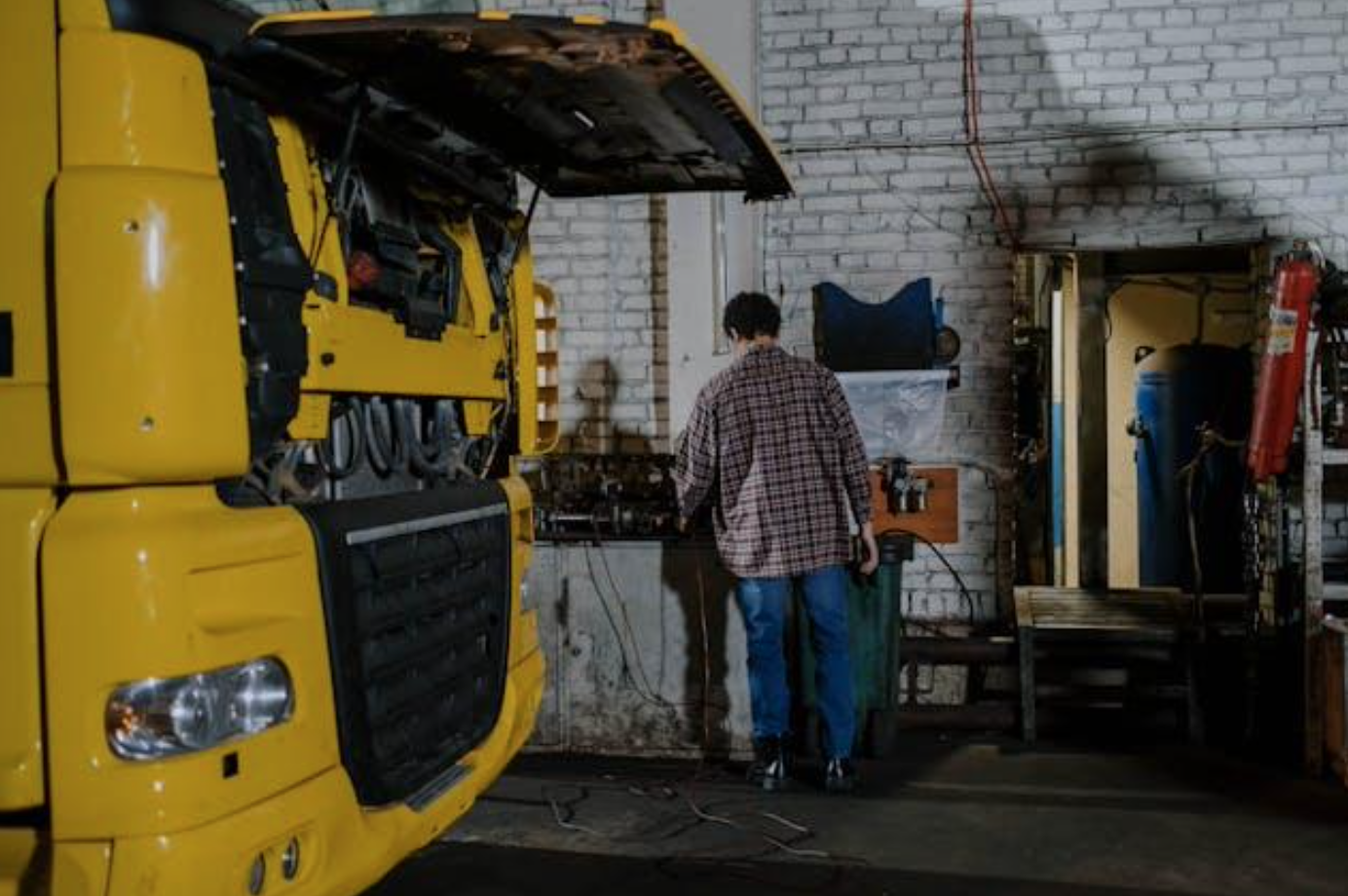 Mechanic repairing truck engine; image by cottonbro studio, via Pexels.com.
