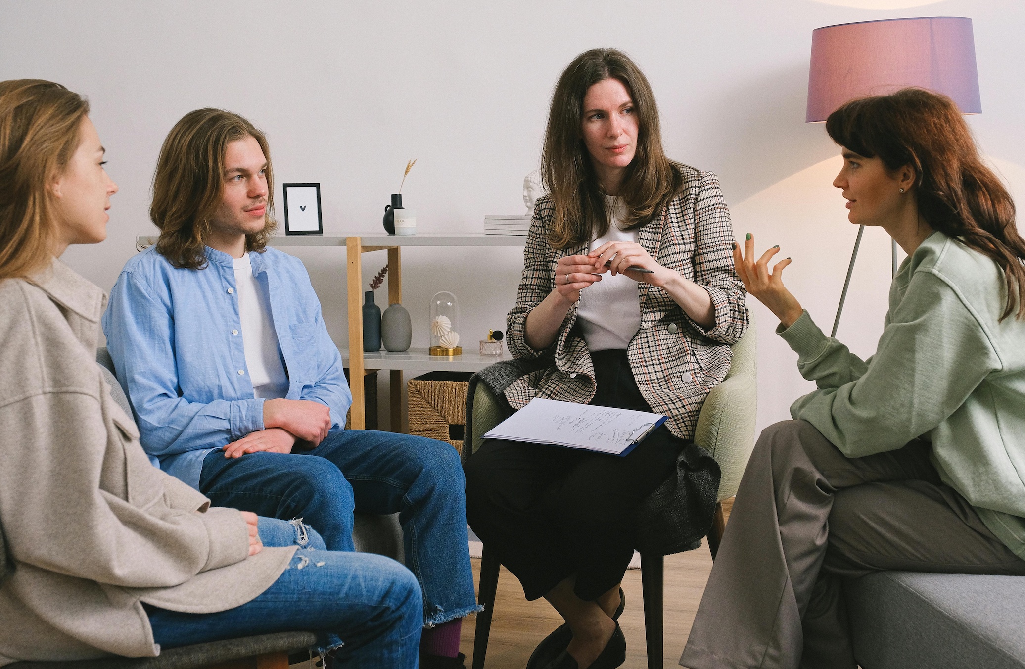 Woman discussing problem during group therapy; image by SHVETS production, via Pexels.com.