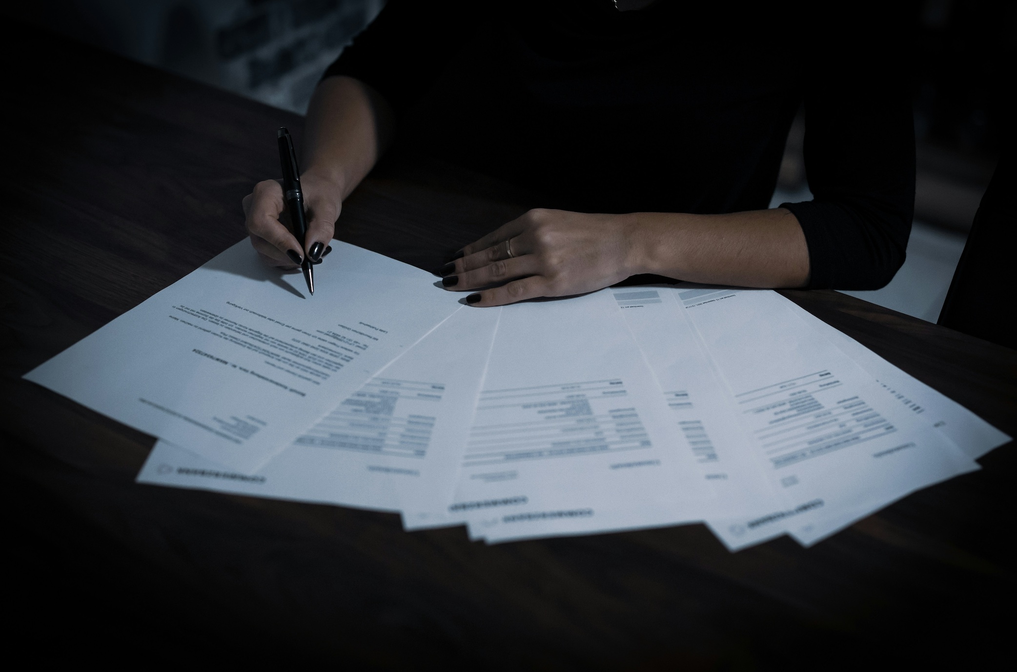 Woman reviewing official documents; image by Dimitri Karastelev, via Unsplash.com.
