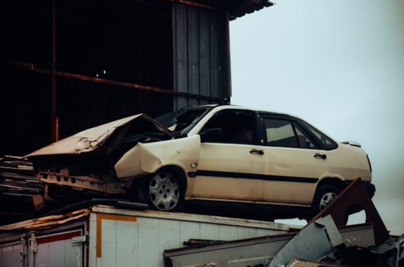 Crushed car on metal scrapheap; image by UMUT, via Pexels.com.