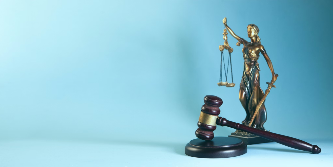 Lady Justice and a gavel on a blue background; image by Sasun Bughdaryan, via Unsplash.com.