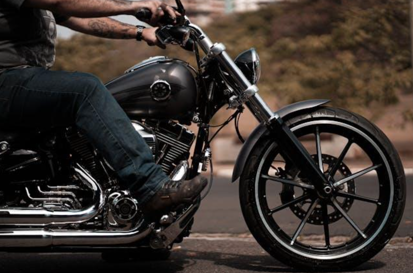 Man in blue jeans riding a motorcycle; image by Wolf Art, via Pexels.com.