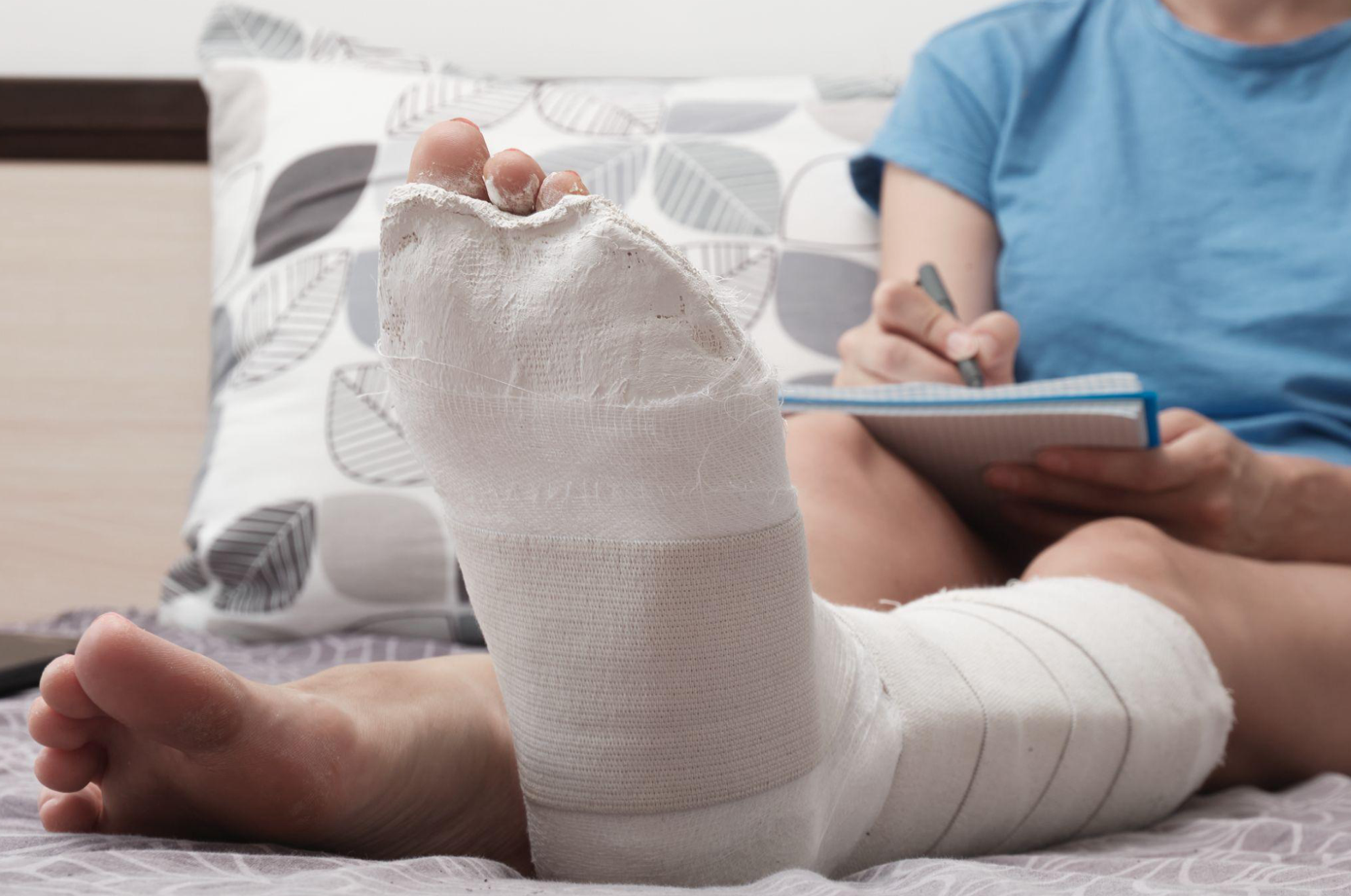 Woman with broken leg works from home; image by Aleksandr Kirillov, via Magnific.com.