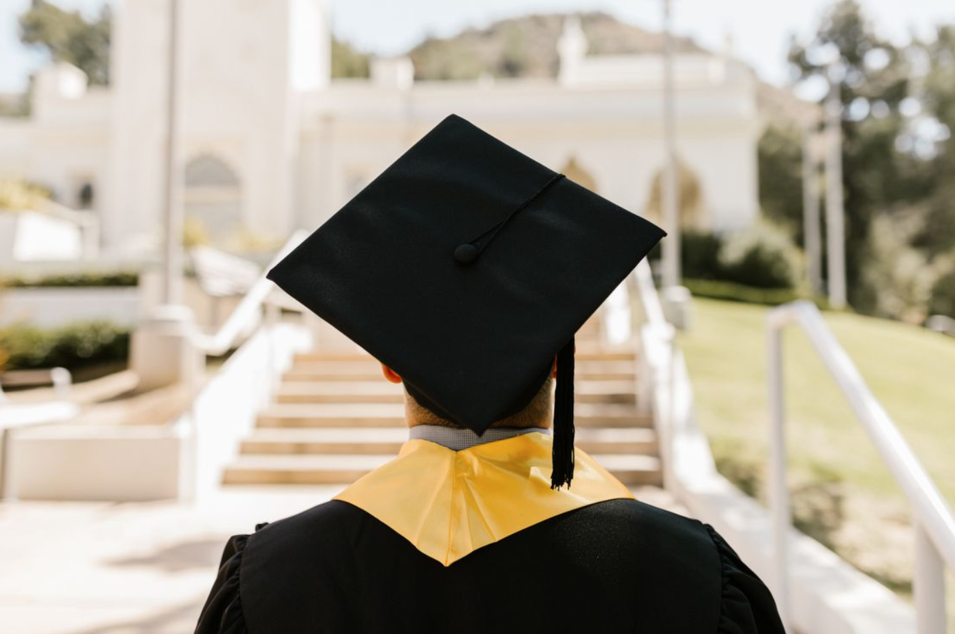 Graduate wearing a mortarboard and gown; image by RDNE Stock project, via Pexels.com.